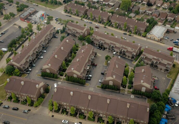 Aerial view of a group of multi-family buildings with newly replaced brown roofs.