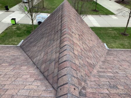 Aging ridge shingles and weathered asphalt roofing system prior to roof replacement in Novi, Michigan.