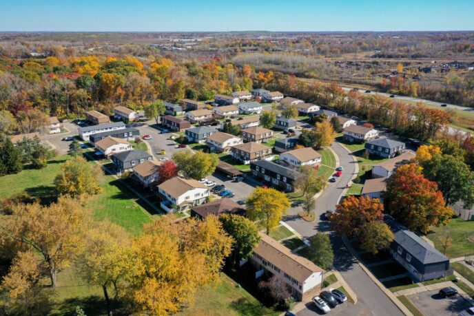 Aerial view of a multi-family neighborhood in Michigan. Homes, colorful trees, and clear blue sky. Multi-Family.