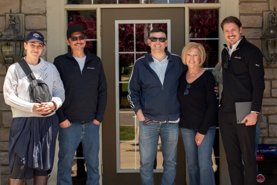 Michigan multi-family roofing team. Group photo of board members and property manager in front of building.