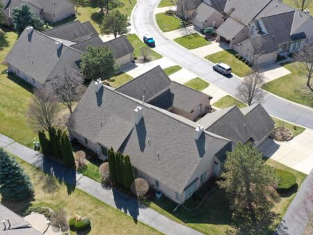 Aerial view of Botsford Commons project site showing residential buildings and landscaping, illustrating project updates by Gulason. Street view with vehicles.