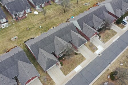 Aerial view of Manors community project, featuring residential homes with gray roofs and driveways.