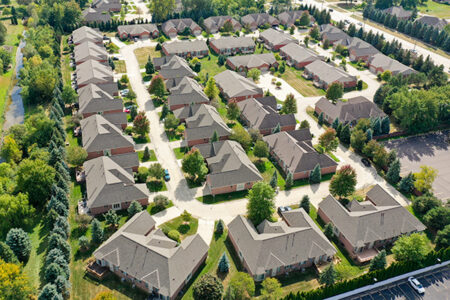 Aerial view of Avalon Meadows condominium community, a current community project. Residential neighborhood with trees and green spaces.