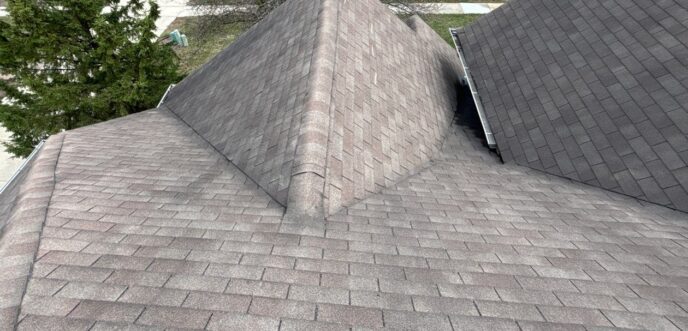 Top down perspective of a residential roof in Plymouth MI displaying worn shingles on the slope and valley junctions before the planned replacement work.