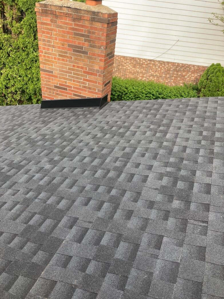 5-Star Roofing: Andrea M.'s Clinton Twp home after roofing. Features gray shingles and a brick chimney. Quality roofing in Clinton Township, Michigan.