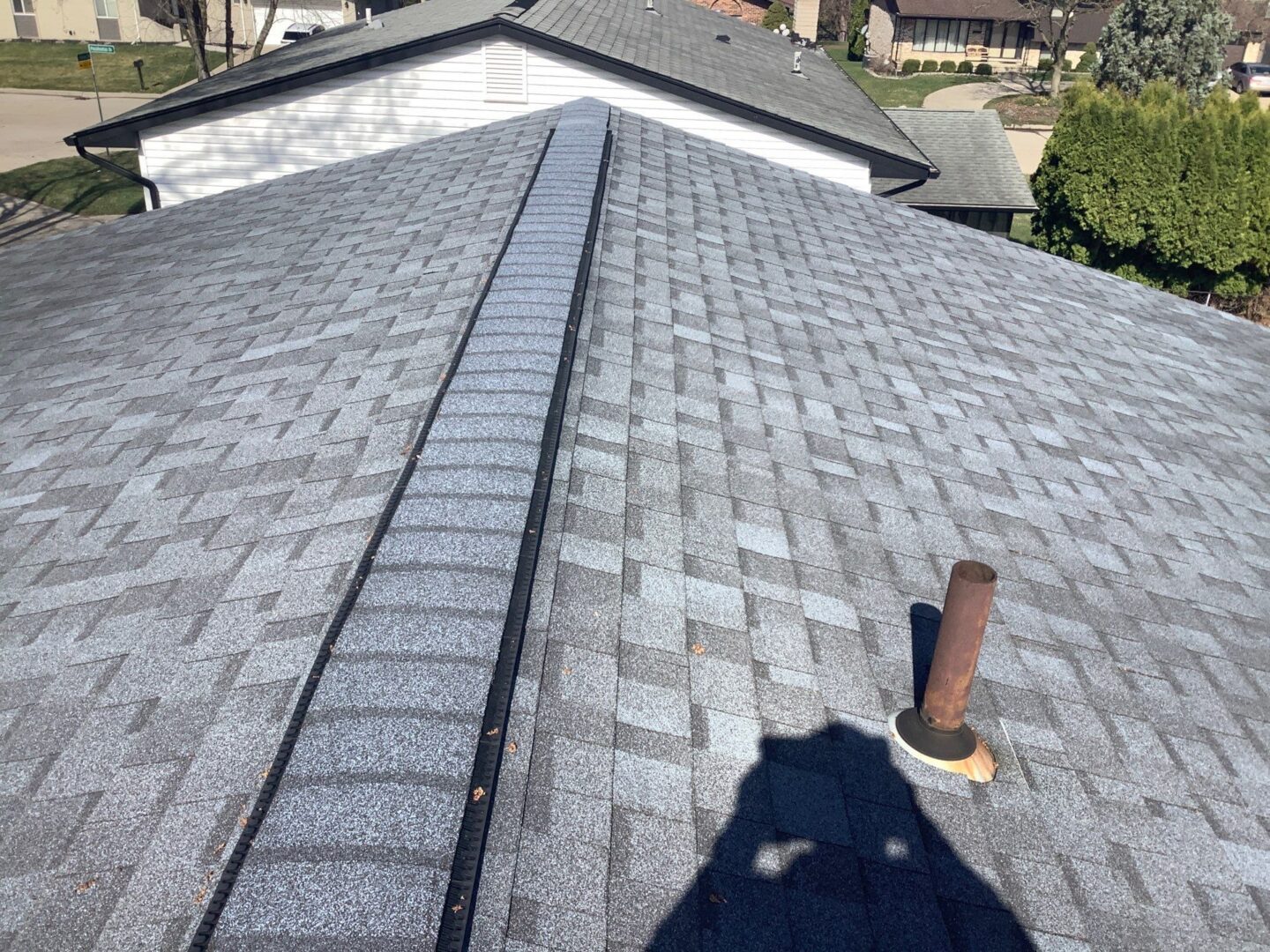 Andrea M.'s before roofing project in Clinton Township, showcasing the existing roof. 5-Star Roofing provides top-tier roofing services. Gray shingles visible.