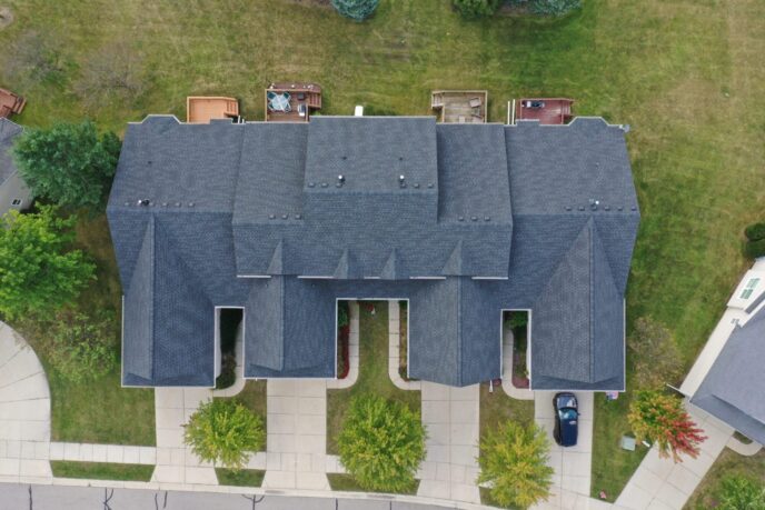 Auburn Grove multi-family community roof replacement. Aerial view of a dark gray shingle roof on a residential building.
