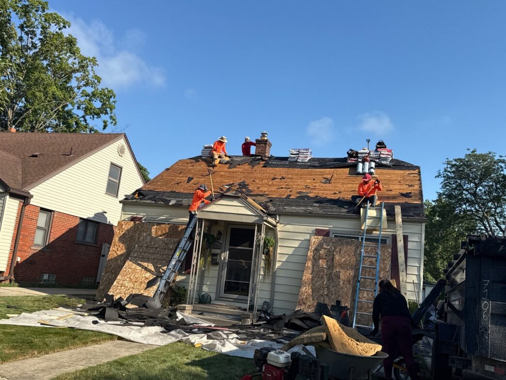 Roofing crew replacing shingles on a house
