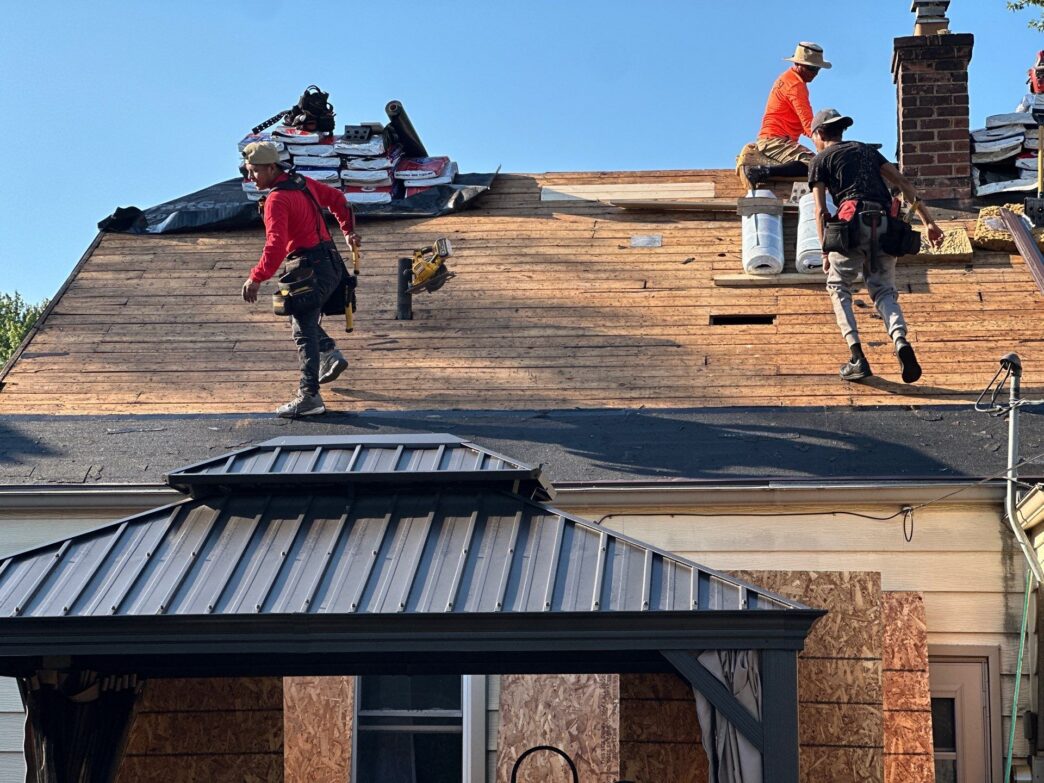 Roofers installing new roofing on a house under construction