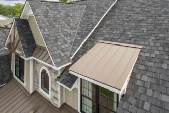 Overhead view of a home with Belmont Black Granite shingles. The luxury shingles provide a sophisticated, durable roofing solution for this home. Polymer shingles on grey house after the snow. New decking required roof covering and ice and water shield