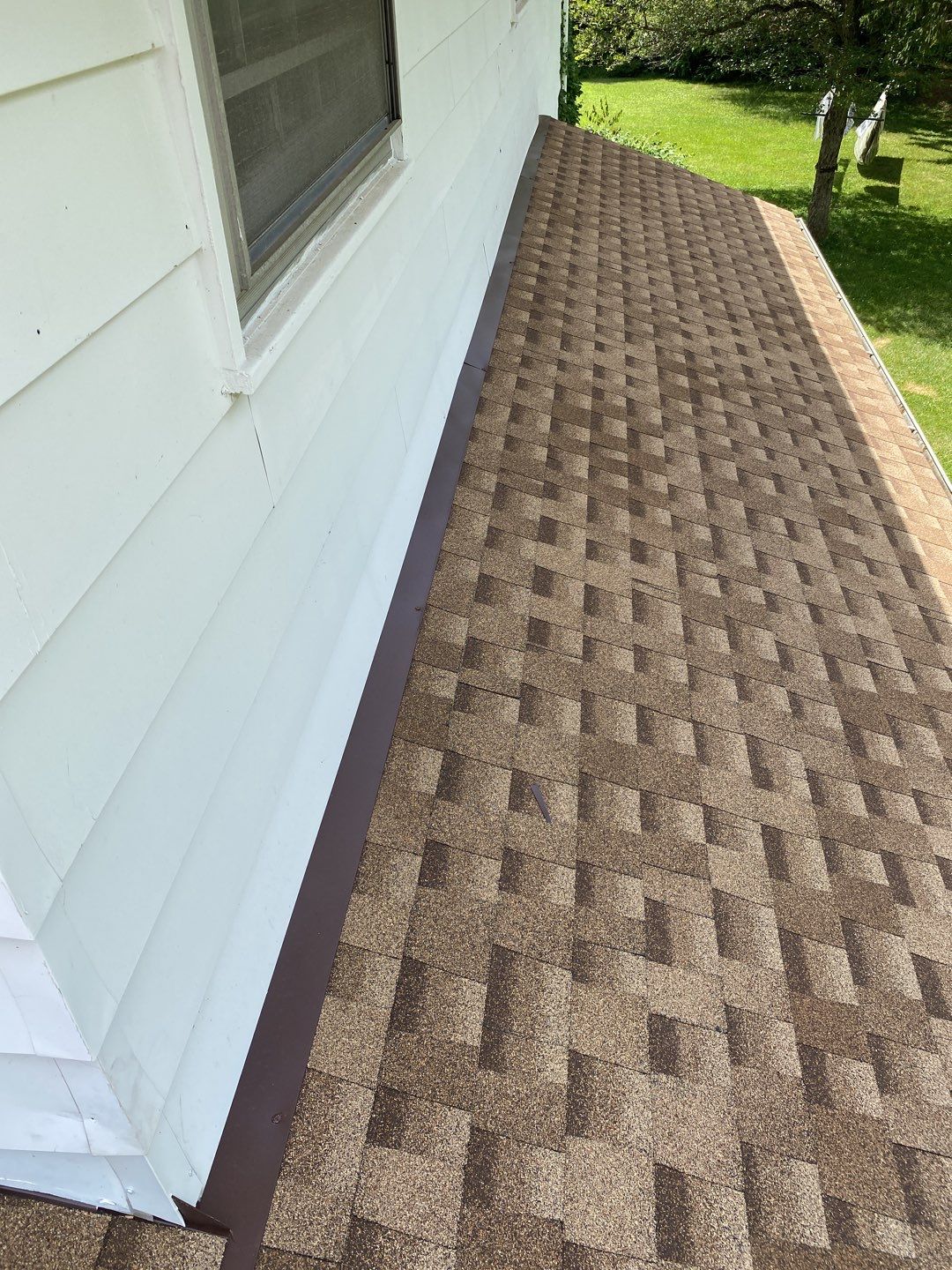 Ann Arbor roof replacement by Bill's! View of the completed roofing project with brown asphalt shingles installed on the house. Excellent roofing.