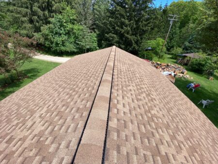 Newly installed Ann Arbor roof replacement by Bill's. Features tan/brown asphalt shingles, showcasing quality roofing work and enhancing home value. After view.