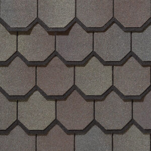 Carriage House by CertainTeed in Gatehouse Slate color. A close-up of roofing shingles shows a textured surface and unique octagonal shape. Durable roofing material.