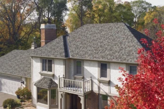 CertainTeed NorthGate ClimateFlex roofing shingle options MI. Shows a home with gray and brown shingles, surrounded by trees in autumn. Durable roofing.