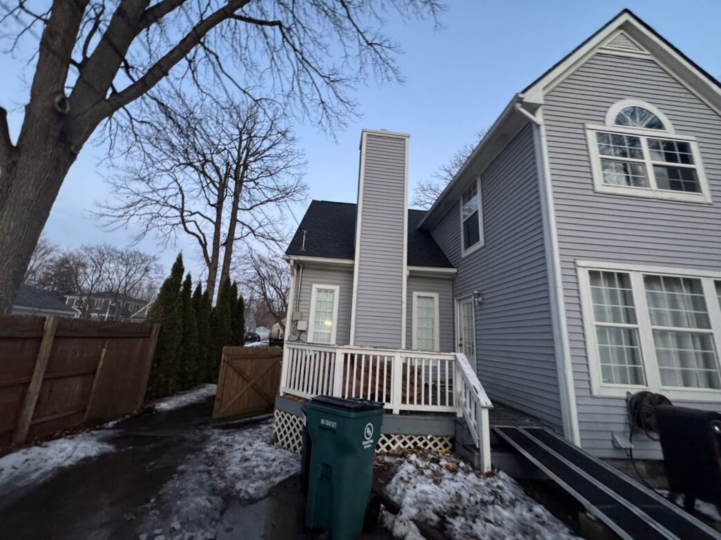 Dan Oshea 5-Star Roofing: Royal Oak home showcasing a new roof replacement, featuring a gray house with a black roof.