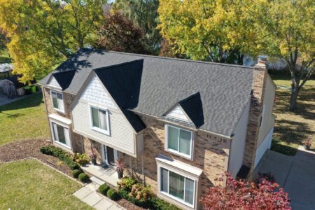 RoofAdvisor: After roof replacement in Novi, MI. Shows a home with a new, dark gray shingle roof. Includes new siding, gutters and downspouts. 