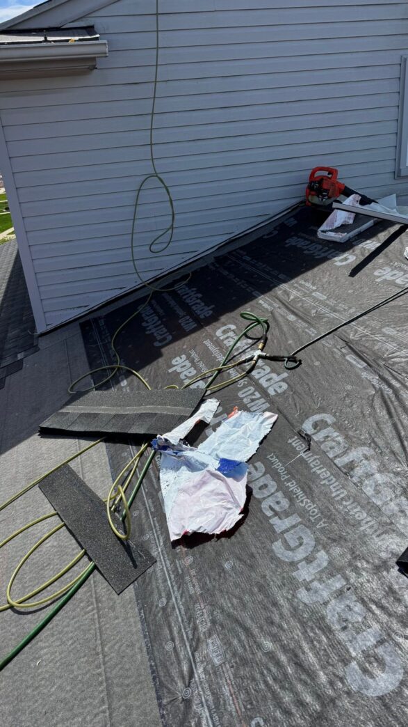 Brownstown roof repair: roofing felt with CraftGrade branding covers roof deck, shingle samples.