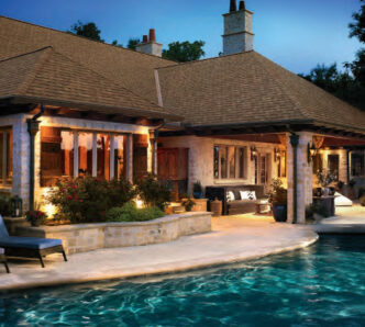 Featured project example: GAF Roofing Camelot II designer shingles in Barkwood color. Luxury home exterior with a swimming pool. Designer shingles on a residential roof.