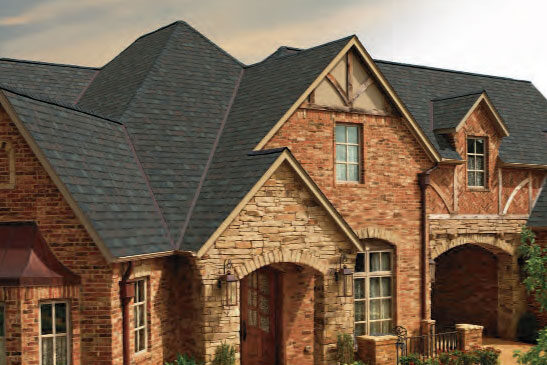 Featured project example: GAF Roofing Camelot II designer shingles in Royal Slate on a brick home. Roofing shingle samples provide a slate look for this example roof.