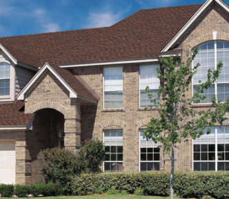 GAF Timberline ArmorShield II example roof in Hickory. Architectural shingles on a brick house with a blue sky in the background. Durable roofing.