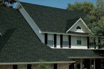 Popular Roof Shingle Timberline HDZ roofing system in Hunter Green on a house roof. Asphalt roofing shingles provide a dimensional, wood-shake look. Durable, affordable roofing.