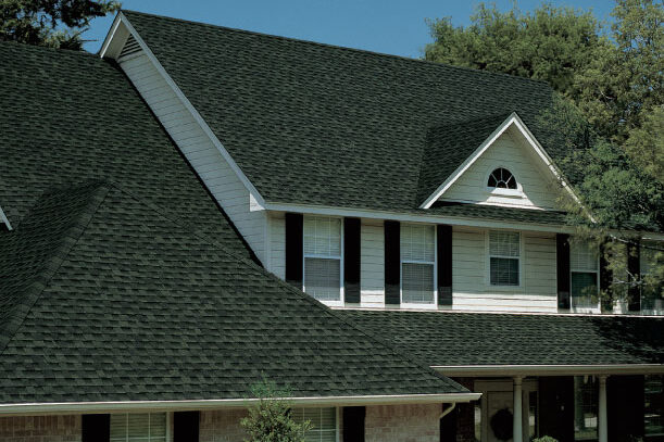 Popular Roof Shingle Timberline HDZ roofing system in Hunter Green on a house roof. Asphalt roofing shingles provide a dimensional, wood-shake look. Durable, affordable roofing.