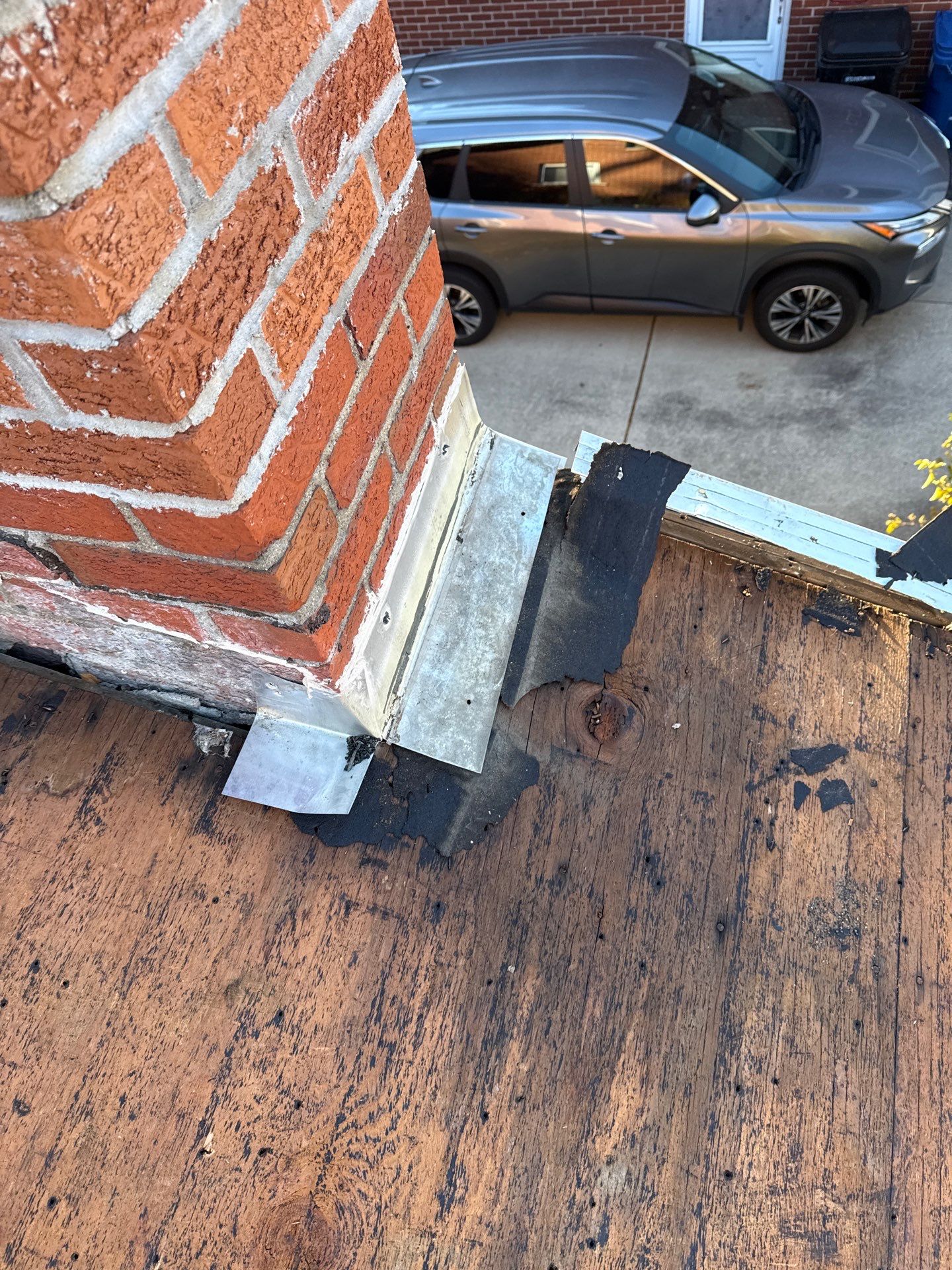 Leila A's 5-Star Roofing project in Redford: Close-up of chimney flashing repair. Expert roofing process showing detail of the roofing system.