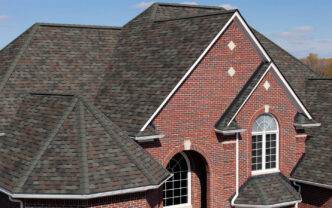 Owens Corning Duration Colonial Slate Shingles on a brick house. Asphalt roofing shingles in gray and brown tones enhance the home's exterior. 