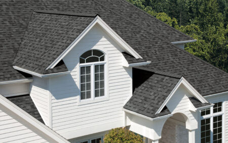 Owens Corning Duration Estate Gray shingles on a white house. Durable roofing solution with a stylish, modern design. Enhancing curb appeal and protection.