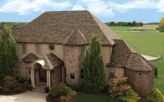 Owens Corning Duration FLEX Roof Shingles in Summer Harvest on a home. A high-quality roofing solution for durability and beauty. Stunning curb appeal. Matching shingles with the brick on home.
