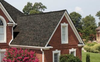 Owens Corning Duration Designer Shingles in Black Sable on a brick home. Close-up showcases the shingle color and architectural style of the roof. 