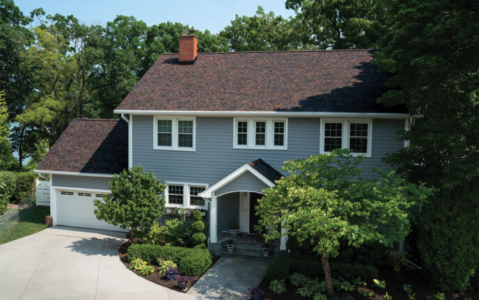 Owens Corning Duration Designer Shingles in Bourbon color on a home. The architectural shingles provide a beautiful, high-end look for enhanced curb appeal.