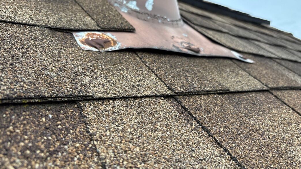 Damaged roofing shingles and rusted flashing on a Plymouth home, requiring 5-Star Roofing repair services by Paul M. Image shows before roof repair.