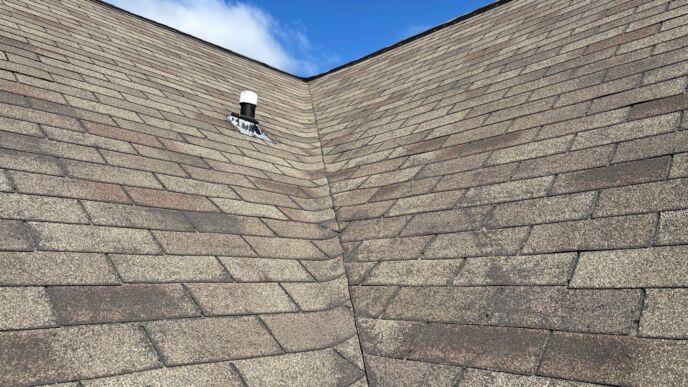 Close-up view of a weathered residential shingle roof valley in Dearborn before a GAF Timberline HDZ shingle replacement.
