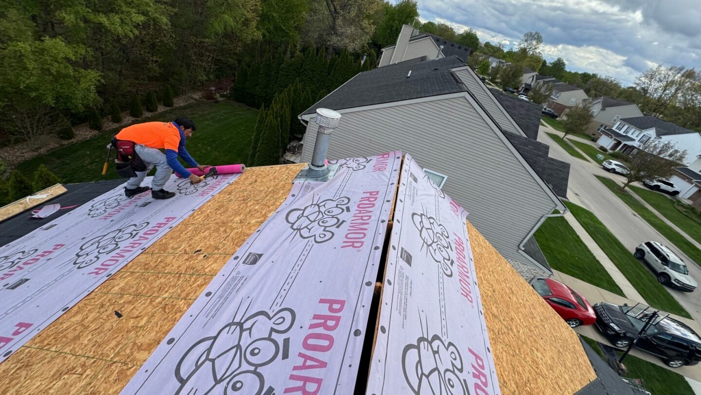 Roofing contractor installing roofing underlayment for 5-Star roofing in Westland, MI.