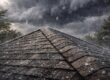 Spring storm roof inspection: Hail falls on a shingled roof during a spring storm, emphasizing the need for roof inspection before storm season hits hard.